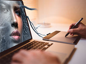 Ein Grafiker arbeitet an einem Laptop und retuschiert in Adobe Photoshop ein Portraitbild – Adobe Photoshop Schulung