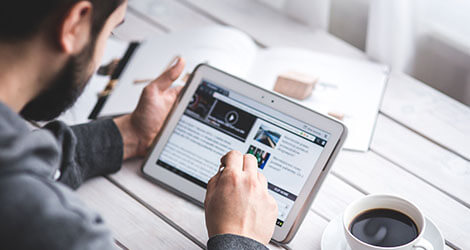 Ein Mann liest an einem E-Reader ein E-Book